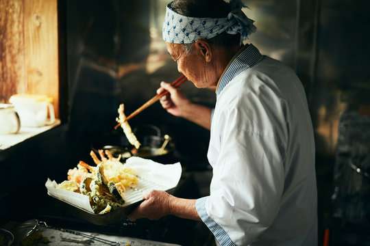 天ぷらを揚げる料理人