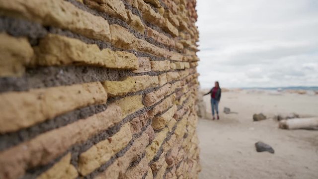 Tourist  girl views a brick wall of an ancient fortress Torre Flavia in Ladispoli