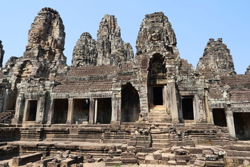 Stone faces of God at Bayon Temple in Angkor Thom, One of the main attractions,  Sculpture carved in ancient times with Hindu belief with blue sky in background at Siem Reap , Cambodia