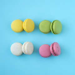 Top view of 4 differents colors macarons on blue