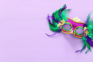 Holidays image of mardi gras masquarade venetian mask over purple background. view from above