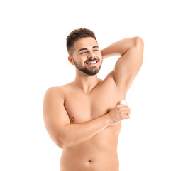 Fototapeta premium Handsome young man using deodorant on white background