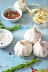 Fresh garlic with spices and herbs on color background