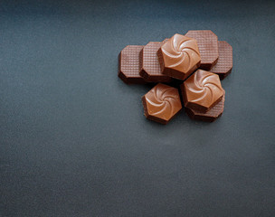 Close up photo of piled up milk chocolates from above view. Copy space