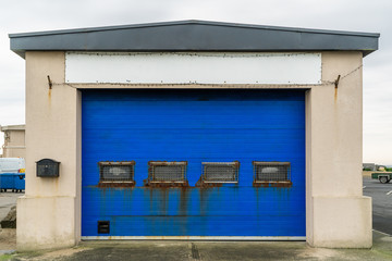 Fototapeta na wymiar Old blue door with rusty windows with metal grilles