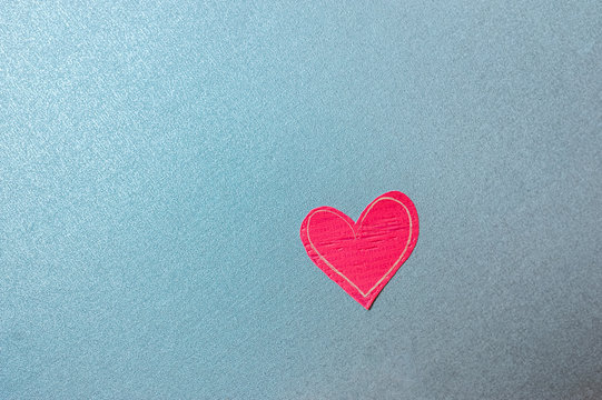 bright red eco-friendly heart made of paper on a uniform blue background, minimalist empty card for a loved one about love and feelings