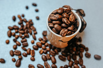 ready-made picture for coffee advertising and ready for publication, a large number of coffee roasted beans are scattered around a white mug full of beans to the brim