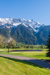 Fototapeta na wymiar Golf course with gorgeous green and fantastic snow mountain view.