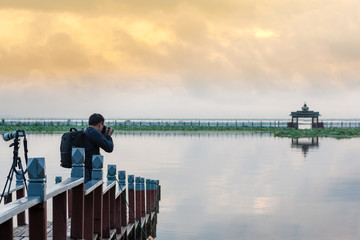Photographer or traveler holding  Digital camera  with take Photo Landscape on blurred background and sunlight in summer time