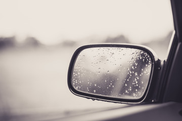 Beautiful car mirror with water droplets and  bokeh in black and white