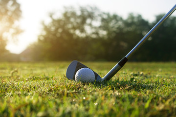 Fototapeta na wymiar Golf clubs and golf balls on a green lawn in a beautiful golf course
