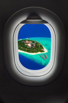 Tropical island at Maldives in airplane window