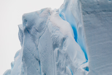 Closeup details of crack in large iceberg floating in the cold water of Antarctica