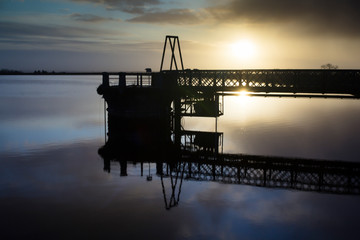 Obraz premium A pier in Craigmaddie reservoir in Milgavie near Glasgow in Scotland on a winters morning. 