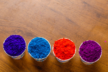 Indian festival Holi concept, colors cup arrange on wooden board 