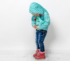 little girl fastening her blue jacket