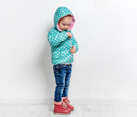 little girl fastening her blue jacket