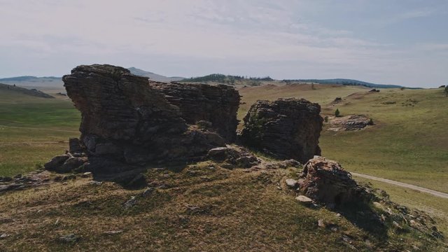 Baikal Valley spirits,Tazheran steppe, stone cliffs on the road. Aerial Summer