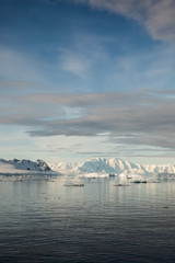 Snow and ice on the mountains near the water in Antarctica, a pristine remote landscape
