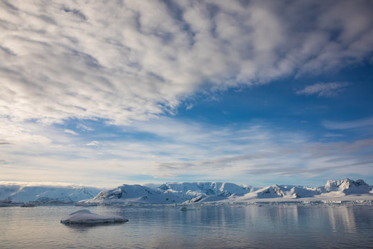 Snow and ice on the mountains near the water in Antarctica, a pristine remote landscape
