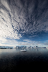 Snow and ice on the mountains near the water in Antarctica, a pristine remote landscape © Gabi