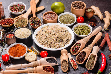 Spices and herbs over black stone background. Top view with free space for menu or recipes