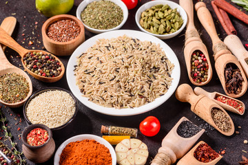 Spices and herbs over black stone background. Top view with free space for menu or recipes