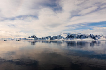 Snow and ice on the mountains near the water in Antarctica, a pristine remote landscape