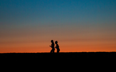 two girls running around the city marathon at sunset