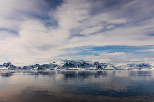 Snow and ice on the mountains near the water in Antarctica, a pristine remote landscape