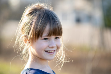 Portrait of a pretty child girl outdoors on a sunny warm autumn day.