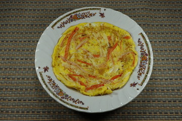 Fried fresh organic egg with crab stick on the plate. Traditional Chicken egg pancake for breakfast menu. High protein and nutrition. Diet food.