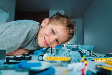 happy boy building robot at robotic technology school lesson