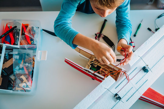 boy making model of plane, kids engineering - Powered by Adobe