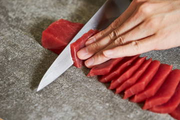 Slicing tuna saku block with sashimi knife