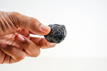 Obraz premium Hand holding sour fruit on white background. 