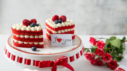 Sweet Valentine. Red velvet cakes in heart shape with berries and red roses bouquet on light background. Copy space