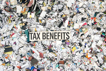 Newspaper confetti from above with the word TAX BENIFITS b