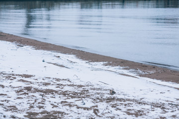 Winter beach: cold water, snow covered sand