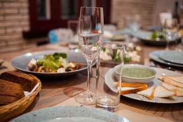 plates with cold appetizers and glasses on the table. close-up