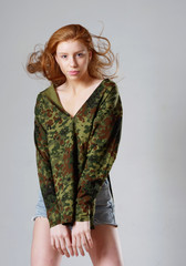 young girl with long red hair on a gray background