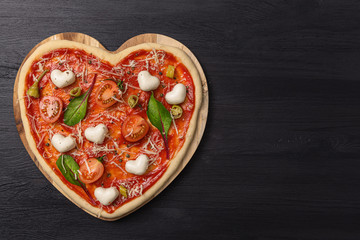 woman preparing a festive dinner for two in honor of Valentine's Day classic Italian pizza Margherita in the shape of a heart and mozzarella in the shape of a heart