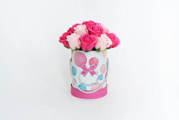 Flowers in bloom: A bouquet of pink and white roses in a round box on a white background.