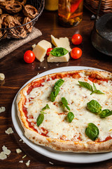 talian Cuisine. Classic Italian pizza Margherita with basil, cheese and tomatoes. Serving dishes in a restaurant on a white plate. background image, copy space text