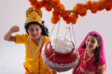 radha and krishna smiling and looking at the earthern pot