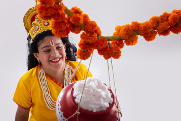 portrait of young krishna looking at dahi handi