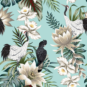 Tropical vintage crane bird, parrot, lotus flower, palm leaves, white orchid floral seamless pattern blue background. Exotic jungle wallpaper.