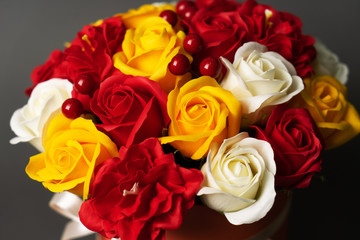Flowers in bloom: A bouquet of red and yellow roses on a grey background.