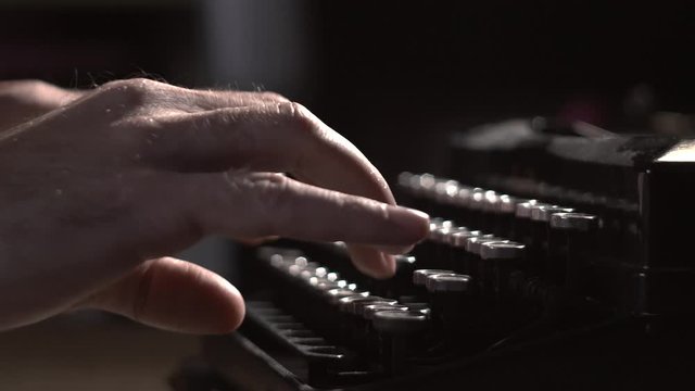 writer types on typewriter keyboard