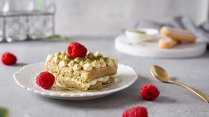 Matcha Tiramisu Dessert with raspberries and Green tea on concrete background. Superfoods, healthy nutrition. Menu, confectionery concept